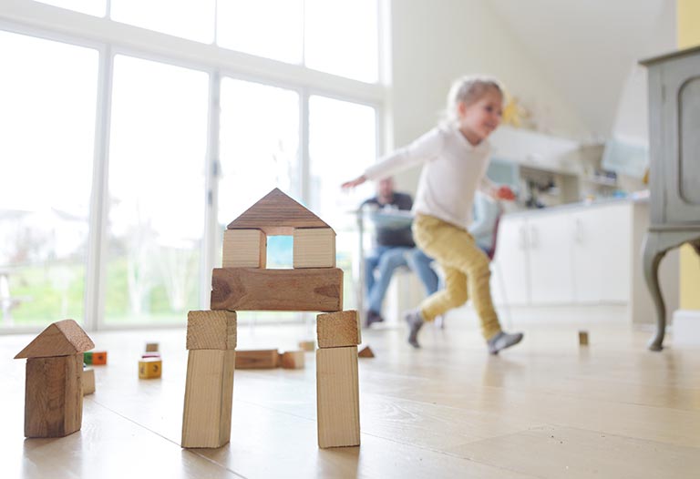 Family at home, child playing with building blocks